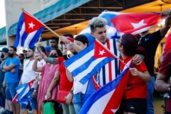 People wave Cuban flags during a protest against the Cuban government at Versailles Restaurant in Miami, on July 12, 2021.