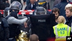 Comandos policiales llevan a un detenido en el operativo antiterrorista en Saint-Denis, cerca de París.