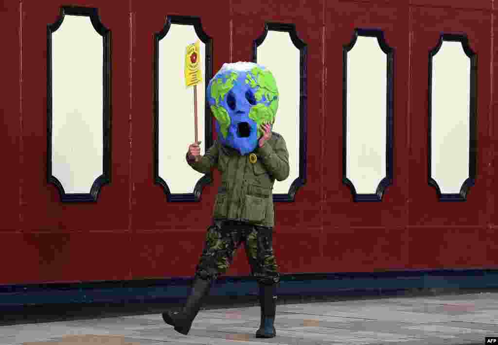 A protester wears a globe mask during an anti-fracking protest at County Hall in Preston, northwest England.