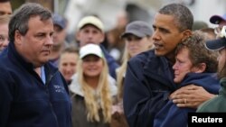 Presiden Barack Obama (kanan), bersama Gubernur Chris Christie (kiri) berusaha menghibur seorang warga di New Jersey yang rumahnya porak-poranda akibat badai Sandy (31/10).