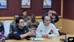 In this image provided by the Royal Thai Police, Chinese actor Wang Xing, right, talks with Thai police officers in Mae Sot district, in Thai-Myanmar border, Tak province, Jan. 7, 2025. 