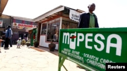 FILE - A man walks away from a retail mobile money transfer shop in Ngong township on the outskirts of Kenya's capital Nairobi.