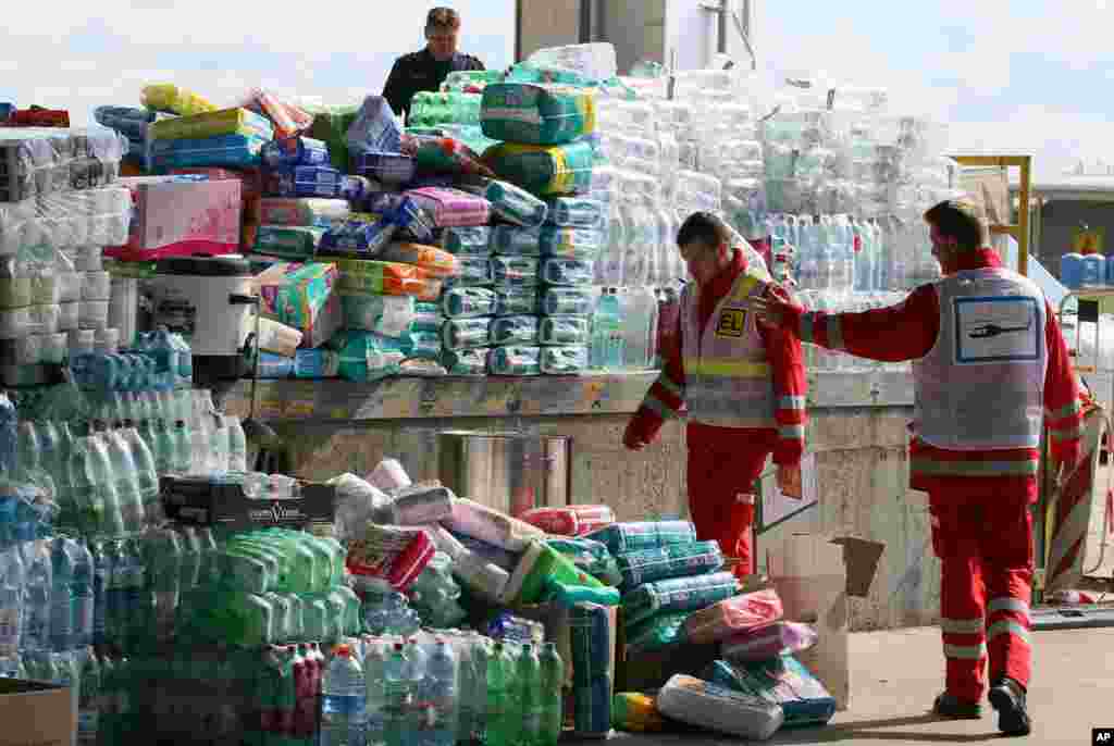 Red Cross workers look at aid goods for migrants at the border between Hungary and Austria, in Nickelsdorf, Austria, Sept. 7, 2015.