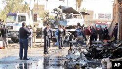 Iraqis inspect the site of a car bomb in the central town of Hilla, south of Baghdad, March 20, 2012.