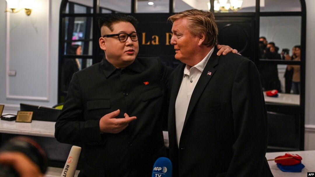 Dua orang yang wajahnya mirip Kim Jong Un dan Donald Trump berbicara kepada media di Hanoi, Vietnam (25/2). Trump-Kim akan mengadakan KTT kedua di Hanoi 27-28 Februari ini. 