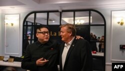 Howard X (kiri), peniru pemimpin Korea Utara Kim Jong Un, dan Russel White, peniru Presiden AS Donald Trump, berbicara kepada media di sebuah hotel sebelum dikawal pejabat berwenang Vietnam ke bandara di Hanoi, 25 Februari 2019. (Foto: AFP)