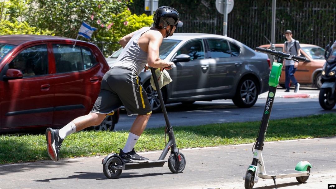 Seorang pria mengendarai skuter di jalanan Kota Tel Aviv, Israel, 30 Mei 2019. (Foto: AFP)