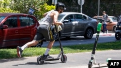 Seorang pria mengendarai skuter di jalanan Kota Tel Aviv, Israel, 30 Mei 2019. (Foto: AFP)