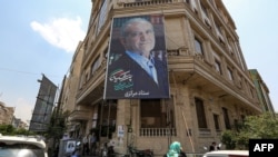 A campaign banner for reformist presidential candidate Masoud Pezeshkian hangs along the facade of a building in Tehran, Iran, on June 26, 2024. Former President Hassan Rouhani endorsed Pezeshkian two days before the election is to take place.