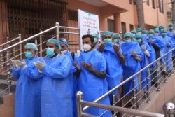 Hospital staff pray before joining their shift, outside a hospital setup for coronavirus infected patients in Quetta, Pakistan, March 26, 2020.