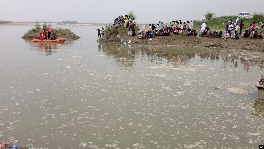 Penduduk desa berkumpul di tepi Sungai Yamuna dekat kota Baghpat di negara bagian Uttar Pradesh, India, saat regu penyelamat beruoaya melakukan pencarian korban kapal terbalik di sungai tersebut, Kamis, 14 September 2017. 