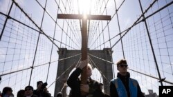 ARCHIVO - Un viacrucis avanza sobre el Puente de Brooklyn después de salir de la Basílica Catedral de St. James, para conmemorar el Viernes Santo y el inicio del fin de semana de Pascua, el 29 de marzo de 2024 en Nueva York, EEUU.