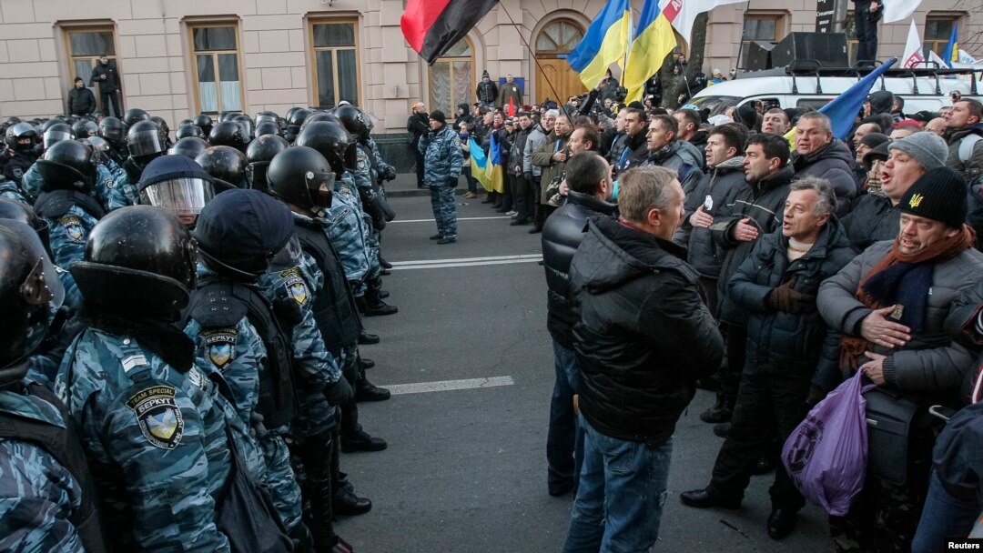 Polisi berjaga di depan para demonstran pendukung integrasi Uni Eropa di depan Gedung Parlemen Ukraina di Kiev (3/12).