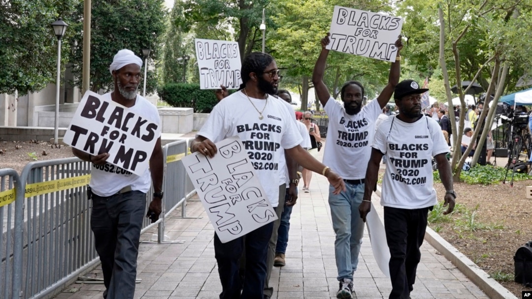 FILE - Supporters of former President Donald Trump with signs and T-shirts that read "Blacks for Trump" gather near the E. Barrett Prettyman U.S. Federal Courthouse, in Washington, Aug. 3, 2023.