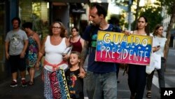 Un migrante venezolano lleva un cartel mientras camina hacia una manifestación en apoyo a Juan Guaidó, en Montevideo, Uruguay, el jueves 7 de febrero de 2019.