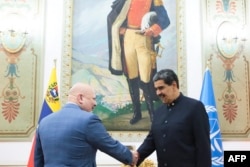 El presidente venezolano Nicolás Maduro saluda en el palacio de gobierno en Caracas al fiscal de la Corte Penal Internacional, Karim Khan, el 22 de abril de 2024.