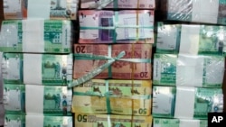 FILE - In this July 24, 2011 photo, Sudan's new currency sits behind a window at the central bank in Khartoum.
