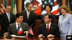 FILE - Mexican Foreign Affairs Undersecretary for North America Geronimo Gutierrez (front left) and Assistant Secretary of Labor for Occupational Safety and Health John Henshaw (front right) pause as they sign a workplace safety agreement, July 21, 2004, in Washington.