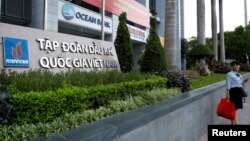 FILE - A woman stands in front of a branch of Ocean Bank located at the Petro Vietnam's building in Hanoi, Vietnam September 1, 2017. (REUTERS/Kham)