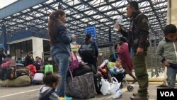 Una familia de venezolanos espera en el puente internacional Rumichaca, en la frontera entre Ecuador y Colombia, el visto bueno de migración para seguir su travesía hacia Chile.