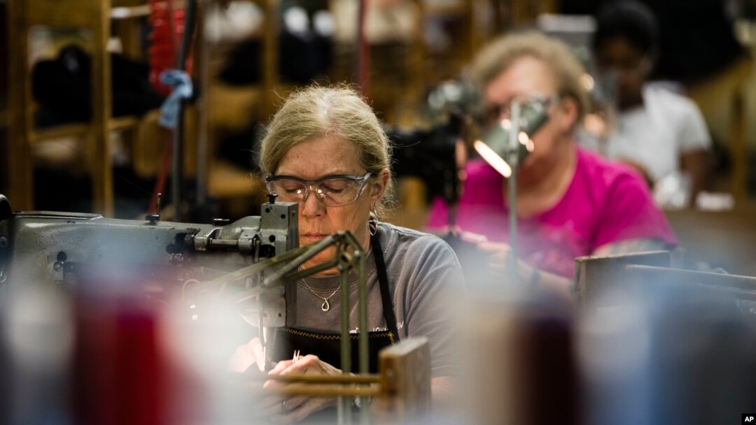 FILE - Workers take part in the manufacturing of Kangol hats the Bollman Hat Company in Adamstown, Pa., May 1, 2017.