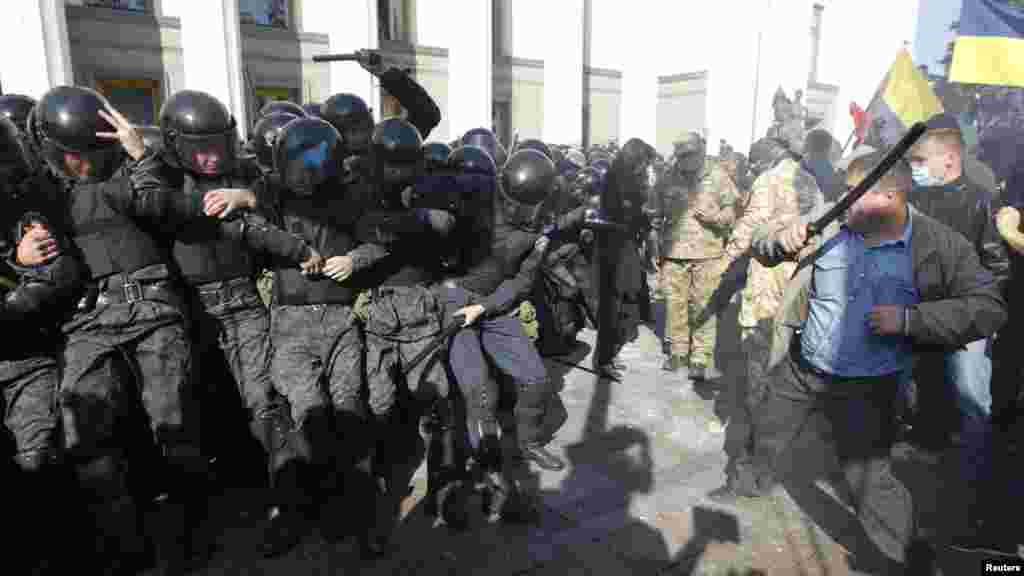 Protesters, right, clash with Interior Ministry and law enforcement members during a rally near the parliament building in Kyiv, Oct. 14, 2014. Thousands of Svoboda nationalist party supporters rallied in Kyiv earlier Tuesday in celebration of the Ukrainian Insurgent Army, but officials from the party denied vehemently that its members were involved in the unrest. 