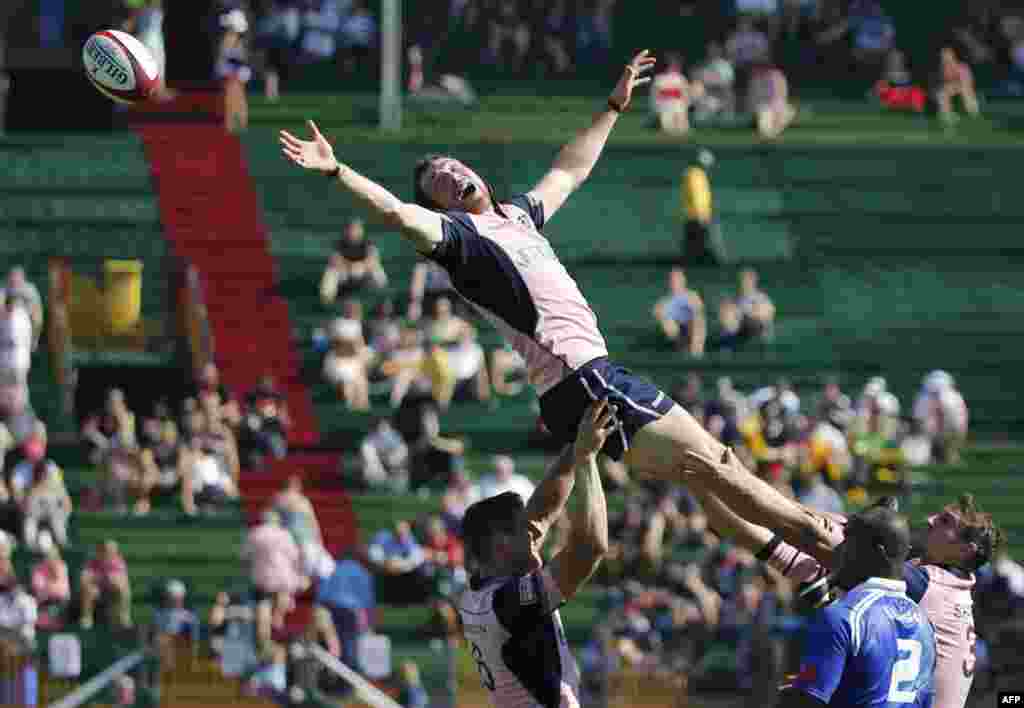 Pemain Skotlandia Scott Riddell (tengah) melompat untuk meraih bola dalam pertandingan rugby melawan Samoa pada hari pertama putaran Dubai Sevens World Series IRB. Empat negara dengan peringkat tertinggi pada akhir kampanye World Seven Series 2014/15 pada bulan Mei akan secara langsung ikut dalam Olimpiade 2016 di Rio de Janeiro. &nbsp;