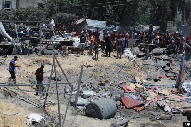 Warga Palestina melihat puing-puing tenda dan berpindah rumah, menyusul serangan militer Israel di kamp al-Mawasi untuk pengungsi internal (IDP), dekat kota Khan Yunis, selatan Jalur Gaza pada 13 Juli 2024. (Foto: AFP)