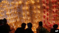 In this photo taken on Wednesday, Nov 25, 2015, contestants arrange paper lanterns on the fire balloon during annual hot air balloon festival in Pyin Oo Lwin, Mandalay Division, Myanmar.