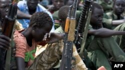 Enfants soldats avec leurs armes lors d'une cérémonie de désarmement, démobilisation et réinsertion à Pibor, Jonglei, Soudan du Sud, le 10 février 2015.