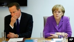 British Prime Minister David Cameron and German Chancellor Angela Merkel meet on sidelines of EU summit, Brussels, Oct. 25, 2013.