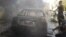 Residents stand next to a damaged car after shelling by forces loyal to Syria's President Bashar al-Assad at al-Saad near Deraa, November 3, 2012. 