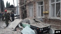 Emergencies personnel work in a damaged area of the city of Ganja following a reportedly Armenian rocket strike on October 4, 2020