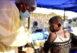 FILE - A Congolese health worker administers Ebola vaccine to a child at the Himbi Health Centre in Goma, Democratic Republic of Congo, July 17, 2019.