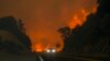 The Line Fire jumps highway 330 as a motorist speeds past, Sept. 7, 2024, near Running Springs, California.