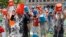 Boston City Councillor Tito Jackson, left in suit, leads some 200 people in the ice bucket challenge at Boston's Copley Square, Thursday, Aug. 7, 2014.