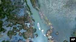 Botes flotan cerca de las orillas inundadas del lago Titicaca en Isla de Cojata, Bolivia, el sábado 9 de marzo de 2024. 