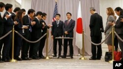 El primer ministro japonés Shinzo Abe (en el centro a la derecha) habla con la prensa luego de reunirse con el presidente electo Donald Trump.