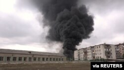 Black smoke rises near buildings during a military conflict over the breakaway region of Nagorno-Karabakh, in Stepanakert, Oct, 4, 2020 in this still image taken from video obtained on October 6, 2020.