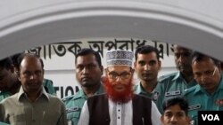 Polisi Bangladesh mengawal Delwar Hossain Sayeedi, tengah, pemimpin partai Jamaat-e-Islami, setelah muncul di pengadilan di Dhaka (21/11).