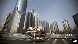 在上海的高樓大廈之間，一個男子騎著三輪車在收廢品，貧富差距令人擔憂