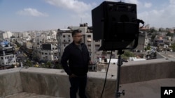Koresponden Al Jazeera layanan bahasa Inggris, Zein Basravi, sedang memberikan laporan langsung dari kantor media itu di Ramallah, di Tepi Barat, Minggu, 5 Mei 2024. (Foto: Nasser Nasser/AP Photo)