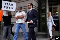 Former Donald Trump presidential campaign adviser George Papadopoulos, center, who triggered the Russia investigation, leaves a federal court with wife Simona Mangiante, June 5, 2019.