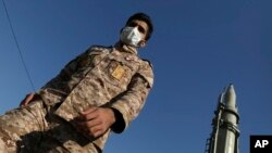 Un membre des gardiens de la révolution passe devant un missile à Téhéran, en Iran, le 7 janvier 2022. 