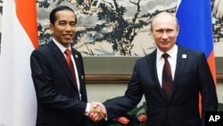 Presiden Rusia Vladimir Putin (kanan) berjabat tangan dengan Presiden Indonesia Joko Widodo pada forum Kerjasama Ekonomi Asia-Pasifik (APEC) di Beijing, 10 November 2014. (Foto: AP)