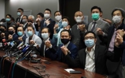 FILE - Hong Kong's pro-democracy legislators pose for a photo before a press conference at the Legislative Council in Hong Kong, Nov. 11, 2020.