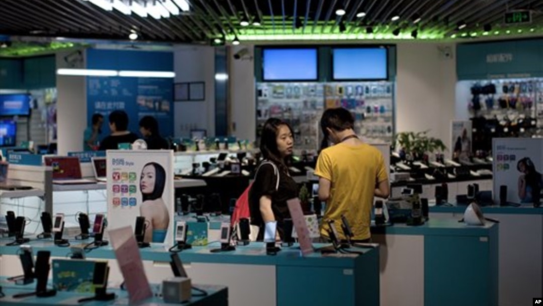 Sebuah pasangan melihat-lihat ponsel di sebuah toko di Beijing. (Foto: Dok)