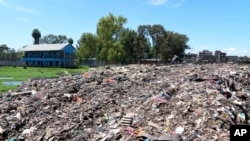 The Dandora Secondary school, next to a mountain of garbage and smoke from burning trash at Dandora, the largest garbage dump in the capital Nairobi, Kenya, April 22, 2024. Students have planted more than 100 seedlings along the wall that separates the school from the dump.