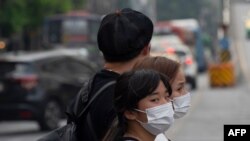 People wear face masks as haze blankets Thailand's capital in Bangkok, Jan. 20, 2020. 