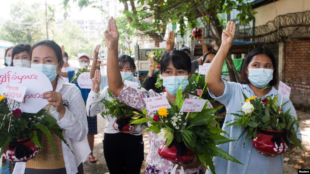 Perempuan membawa pot dengan bunga untuk mengambil bagian dalam protes terhadap kudeta militer di Yangon, Myanmar 13 April 2021. (Foto: Reuters)